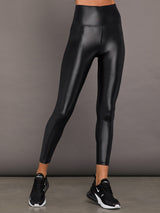 Model wears a high waisted pair of liquidy shine black leggings that hit at model's mid to low calf.