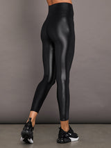 Model wears a high waisted pair of liquidy shine black leggings that hit at model's mid to low calf.