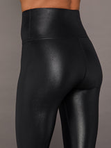 Model wears a high waisted pair of liquidy shine black leggings that hit at model's mid to low calf.