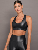 Model wears a black v-neck sports bra in a liquid metallic shine finish.