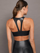 Model wears a black v-neck sports bra in a liquid metallic shine finish.