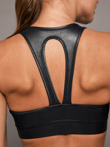 Model wears a black v-neck sports bra in a liquid metallic shine finish.