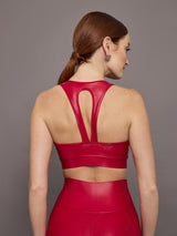 Model wears a bright red shiny, liquidlike sports bra with a v neck. 