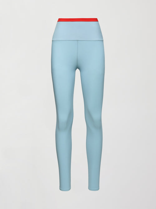 A light blue performance legging with a red waistline. 