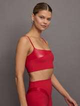 Model wears a cropped red tank with spaghetti straps with a shiny takara overlay in the top right.