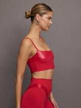 Model wears a cropped red tank with spaghetti straps with a shiny takara overlay in the top right.