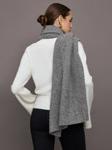 Model wears an oversized heathered grey colored scarf around her neck. 