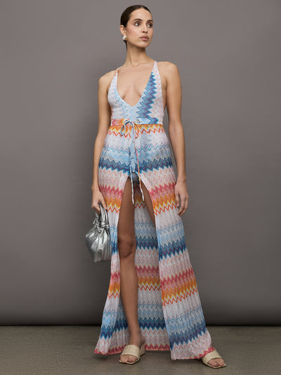 Model wears a high waisted drawstring floor length skirt with an A-line hem up the center and patterned multicolor chevron.