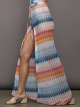 Model wears a high waisted drawstring floor length skirt with an A-line hem up the center and patterned multicolor chevron.