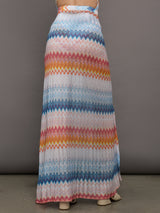 Model wears a high waisted drawstring floor length skirt with an A-line hem up the center and patterned multicolor chevron.